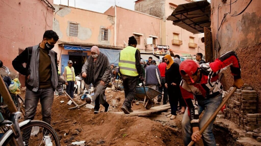 Volunteers engaging in road repairs in a busy urban neighborhood.