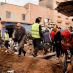 Volunteers engaging in road repairs in a busy urban neighborhood.