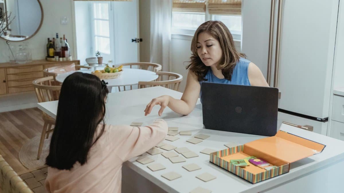 Mother and daughter enjoying a memory game together, indoors on a casual day.