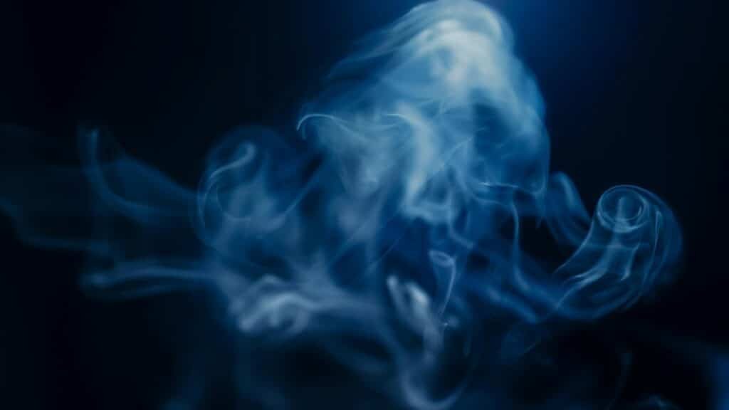 An ethereal composition of swirling blue smoke on a dark background, creating a mysterious and magical atmosphere.