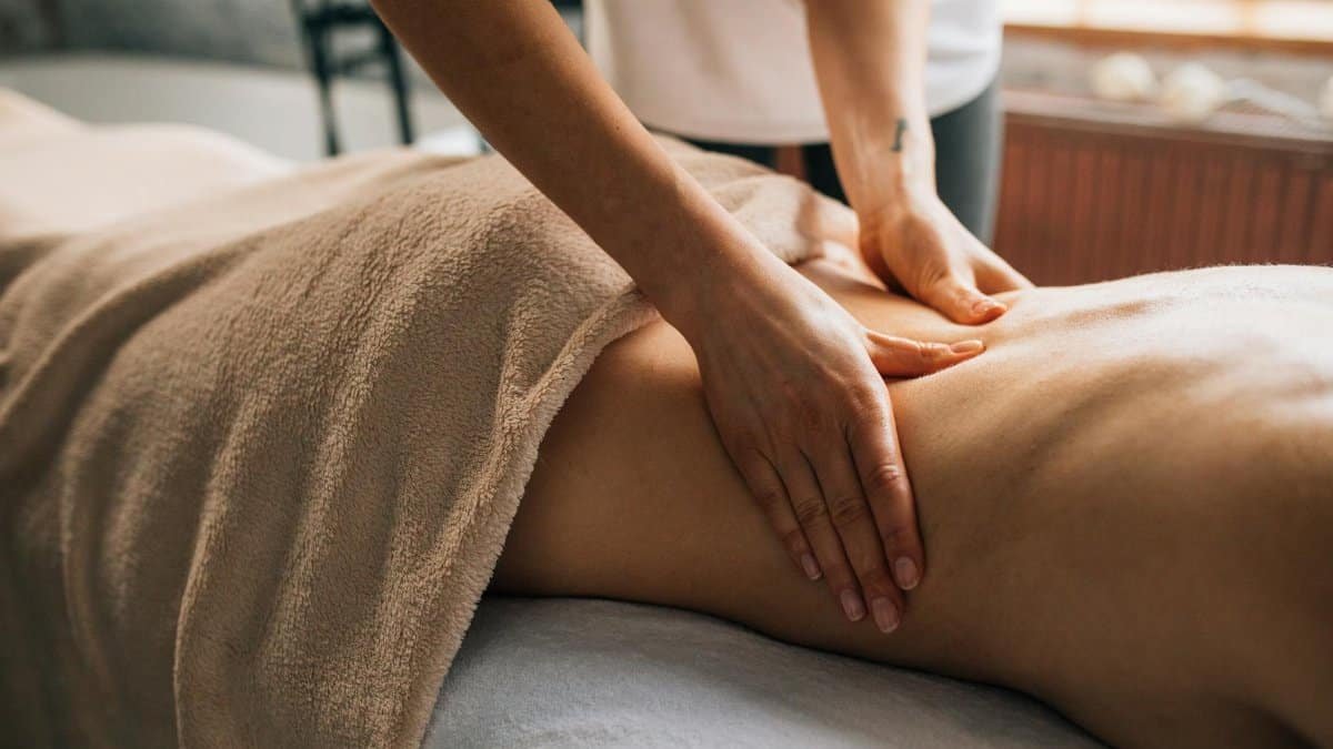 A serene massage session indoors highlighting hands-on body care and relaxation.