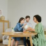 Two children and a teacher explore a globe together indoors, promoting education.