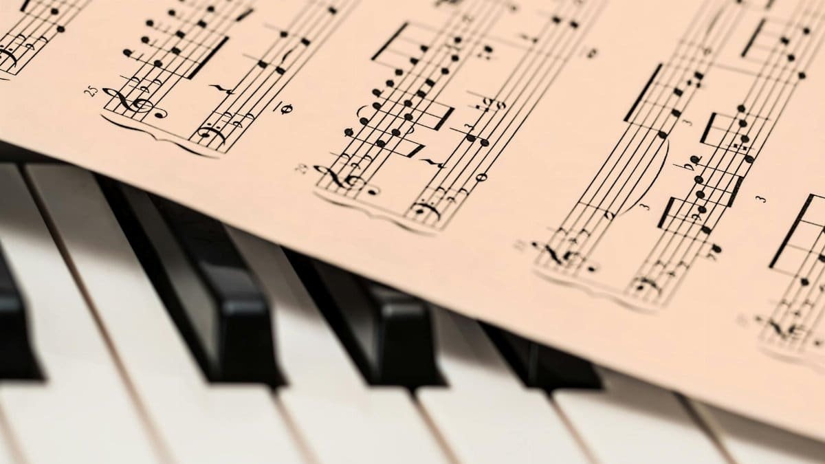 Black and white piano keys with a sheet of classical music creating a harmonious composition.