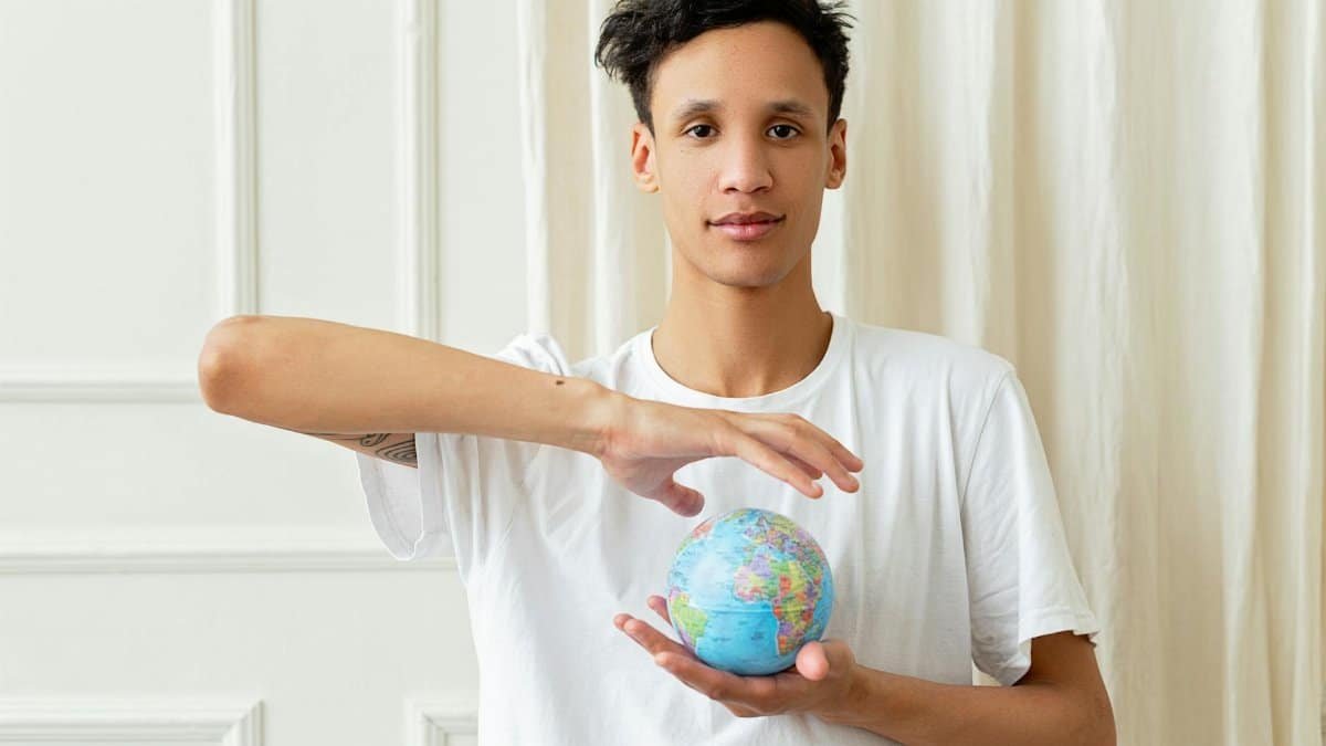Portrait of a young man holding a globe, symbolizing global awareness and volunteerism.