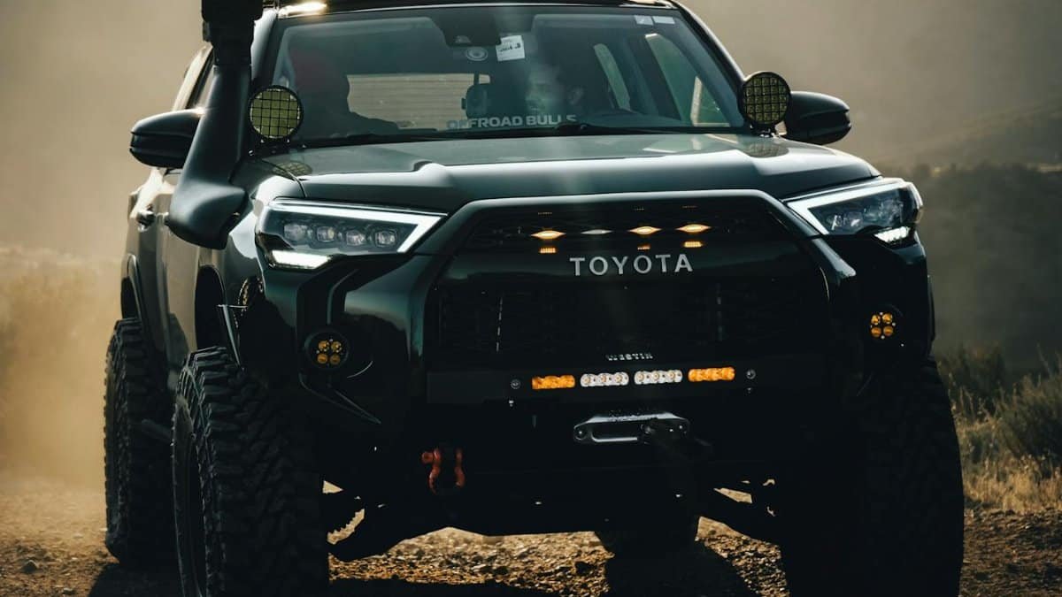 Powerful Toyota truck navigating rugged terrain in dusty conditions.