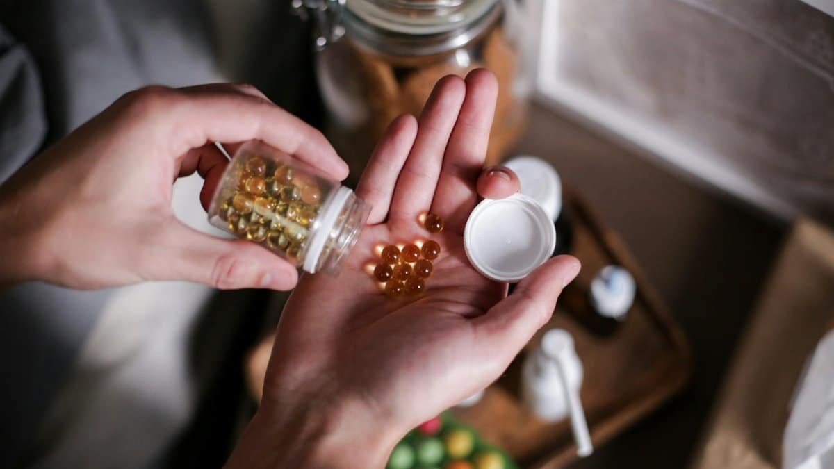 Hands carefully holding supplement capsules, representing health and wellness.