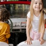Happy children enjoying a playful moment in a classic red convertible car indoors.
