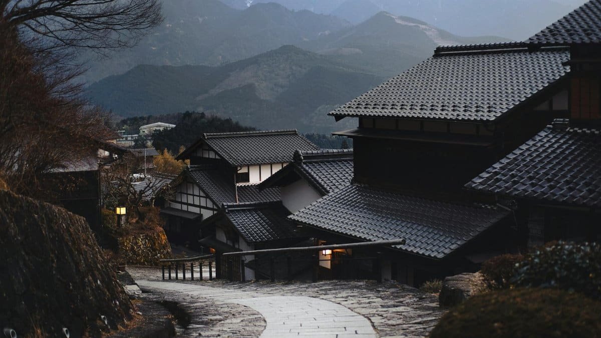 Scenic view of a traditional Japanese village nestled in the mountains during twilight.