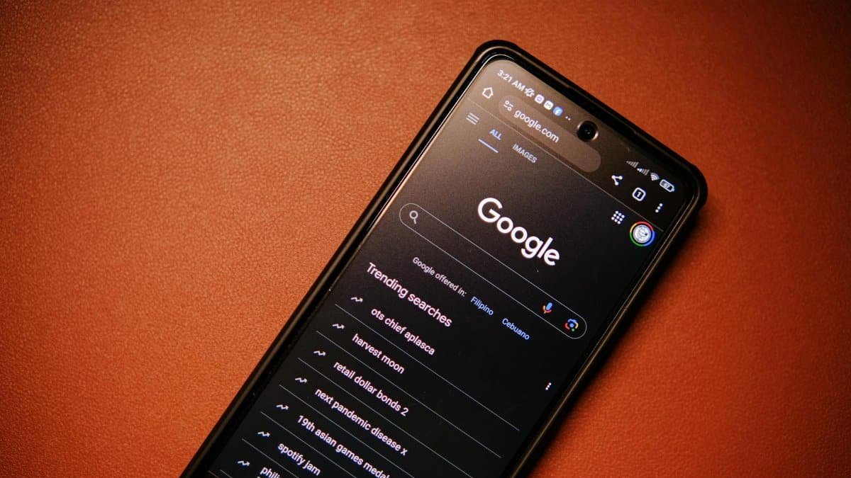 A smartphone displaying Google Search trends on a table at night.