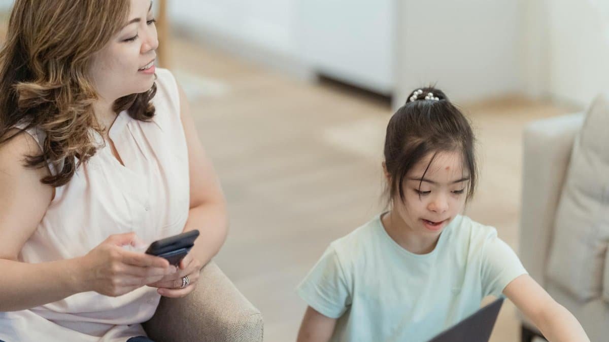 A mother and daughter enjoying a tech moment together at home, fostering connection and learning.