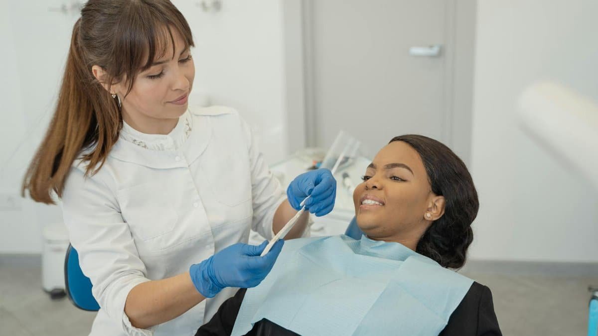 A dentist provides care to a patient during a dental checkup in a clinic setting.