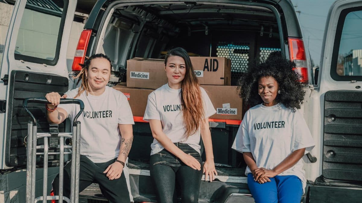 Volunteers organizing medicine and aid supplies for community distribution outdoors.