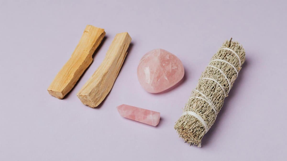 Rose quartz and sage arrangement on lavender backdrop, ideal for meditation and rituals.