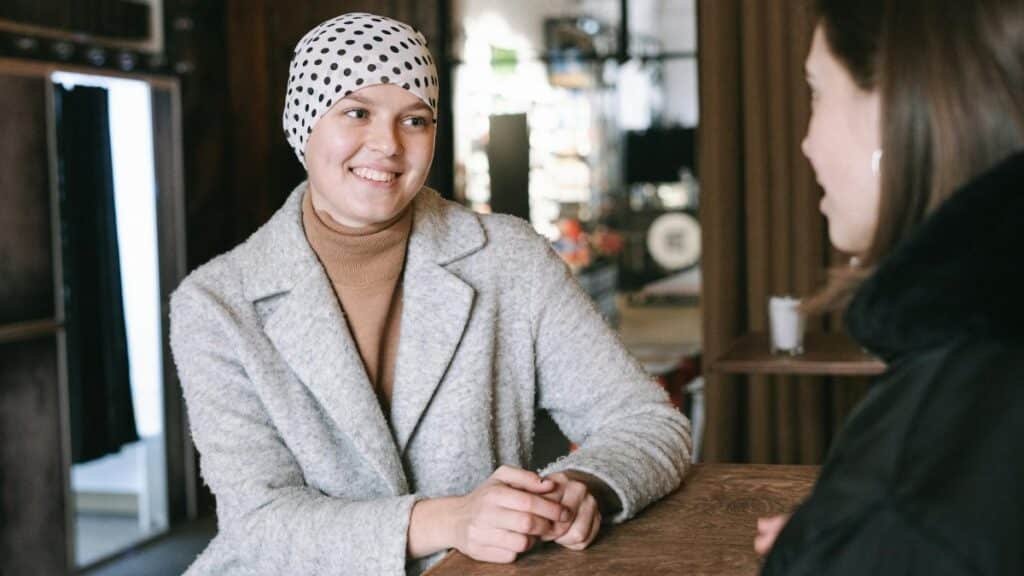 Two women enjoying a heartfelt conversation in a cozy coffee shop, dressed warmly.