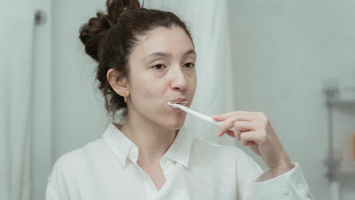 Young woman practicing dental hygiene by brushing her teeth in the morning.