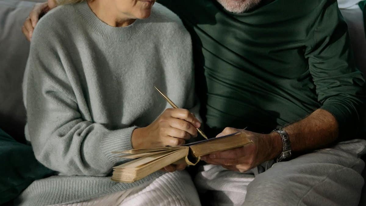 Elderly couple writing together in a cozy living room, sharing memories and affection.