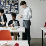 Three diverse students solving Rubik's Cubes in a classroom, fostering teamwork and learning.