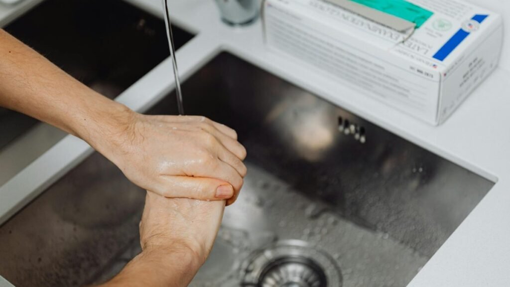 Detailed view of hands being washed under a tap, emphasizing hygiene and sanitation.