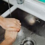 Detailed view of hands being washed under a tap, emphasizing hygiene and sanitation.