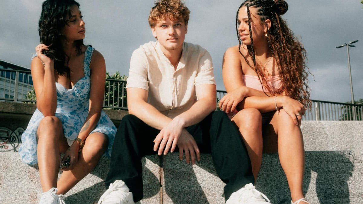 A diverse group of friends sitting on steps outdoors, enjoying a sunny day together.