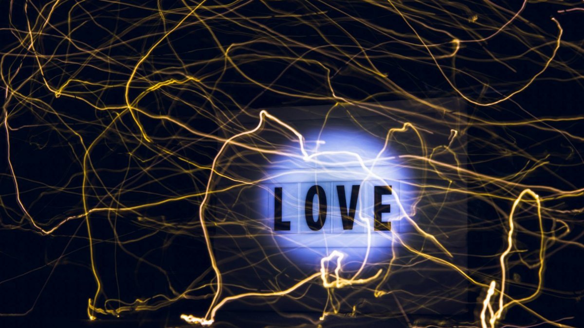 Creative abstract art featuring glowing neon lights and the word 'LOVE' on a dark background.
