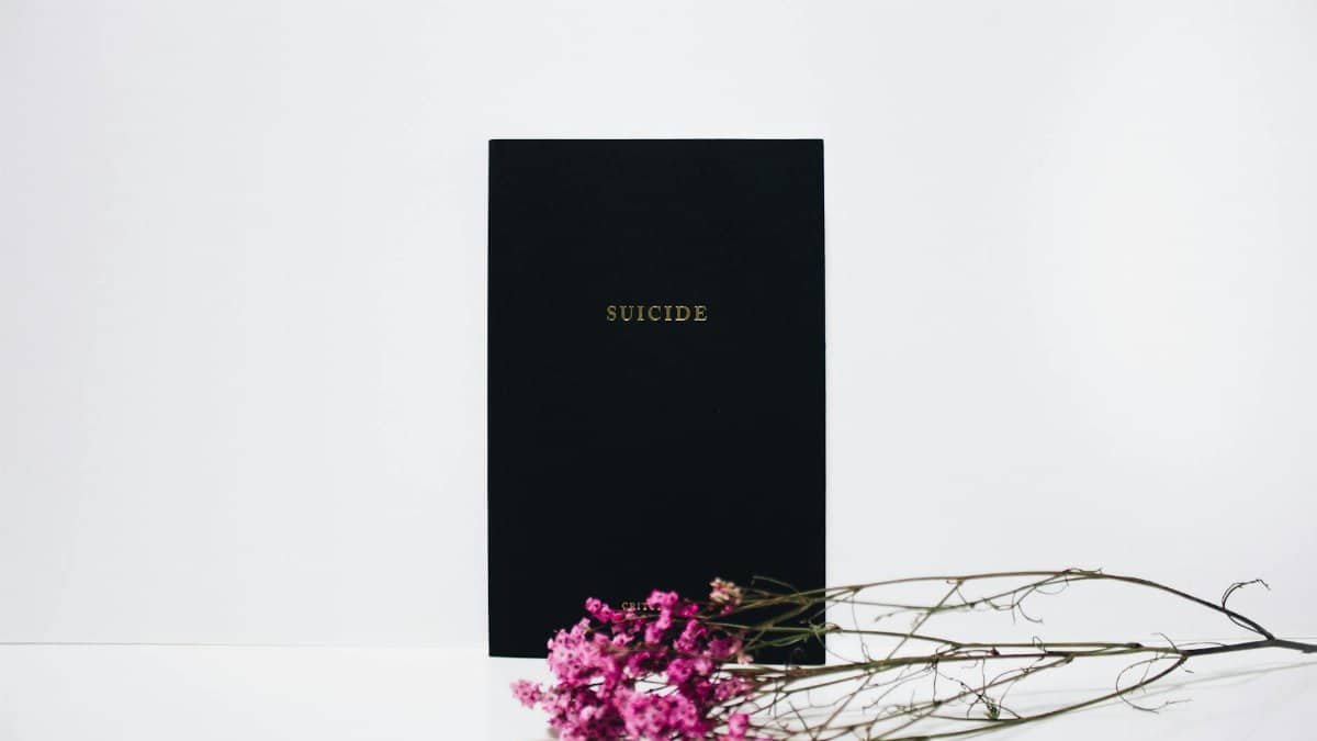 Minimalist art highlighting suicide awareness with flowers on a white background.