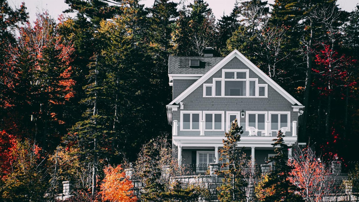 Elegant family home set against a vibrant autumn forest backdrop.