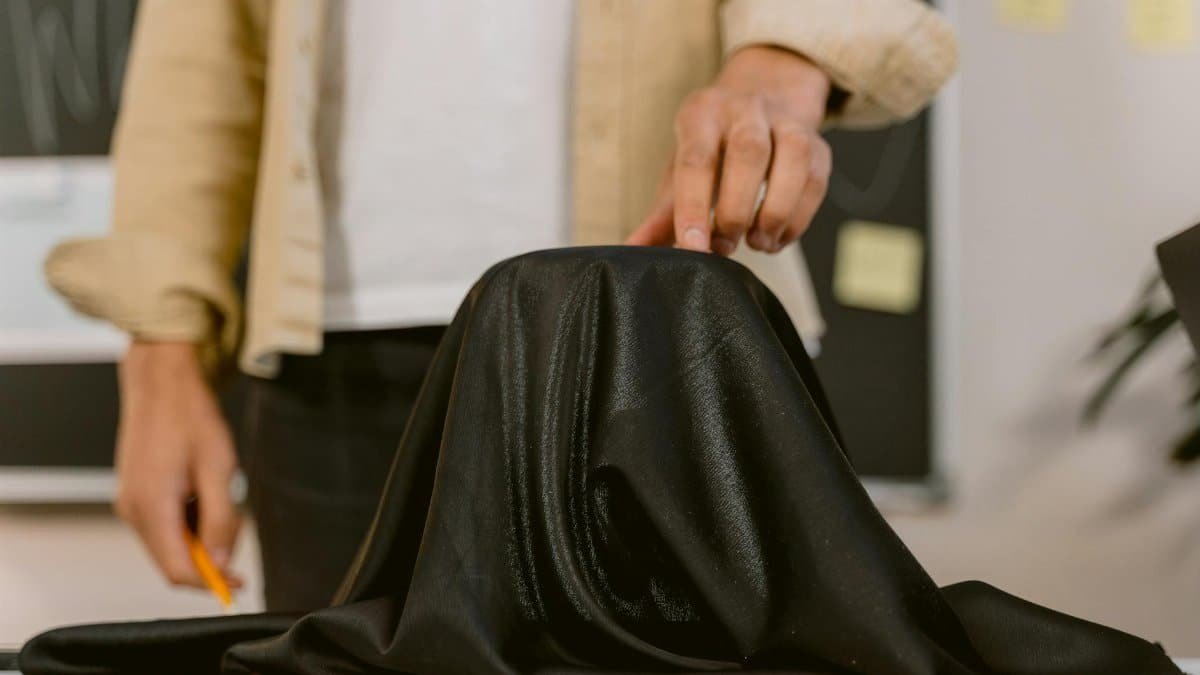 Close-up of a hand pulling a black cloth, showcasing a mysterious setup.