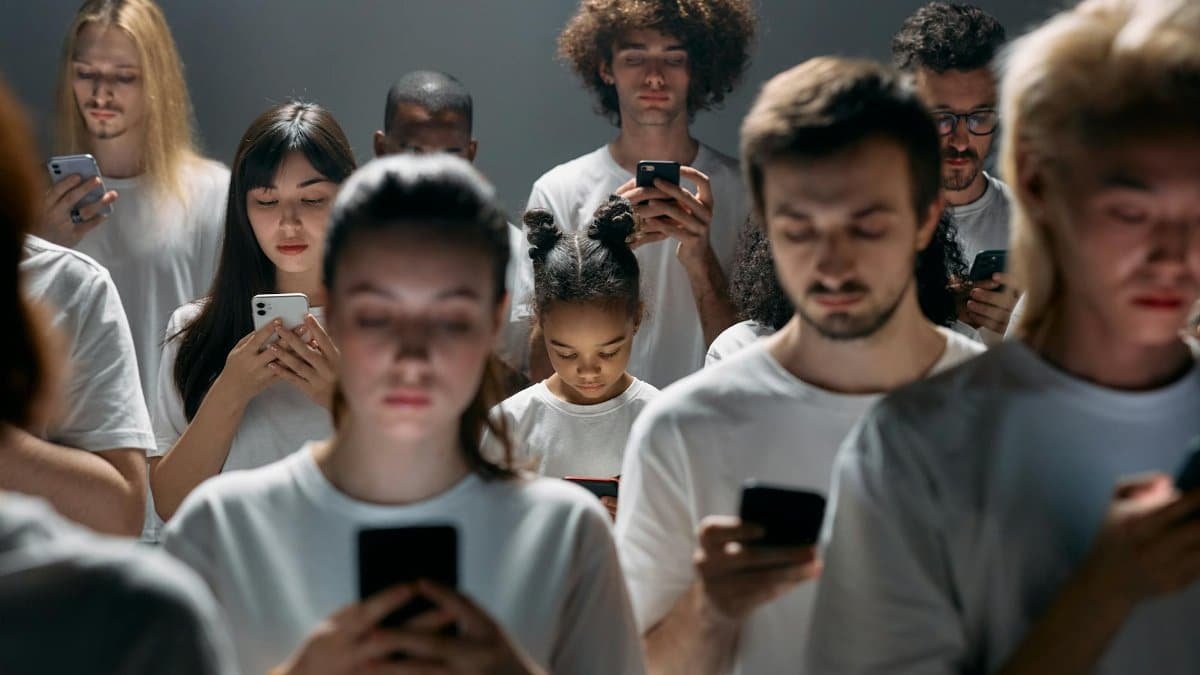 A diverse group of people engrossed in their smartphones, highlighting modern social connectivity.