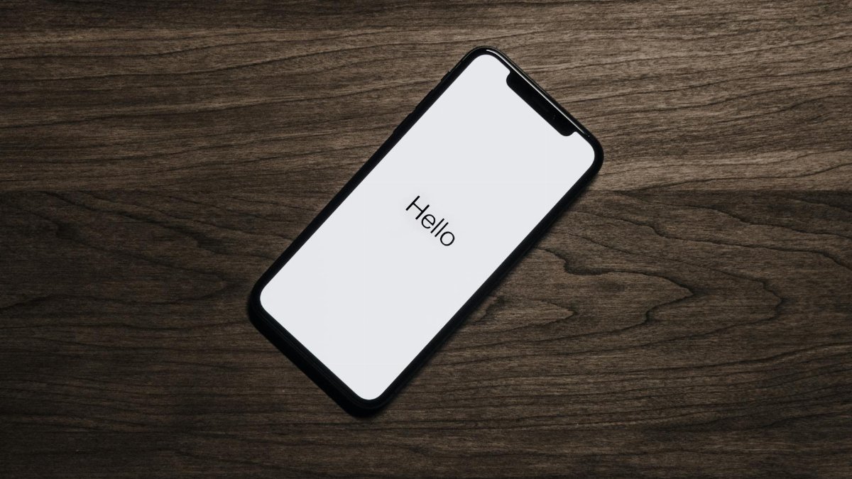 A smartphone displaying 'Hello' on a wooden surface, showcasing modern technology.
