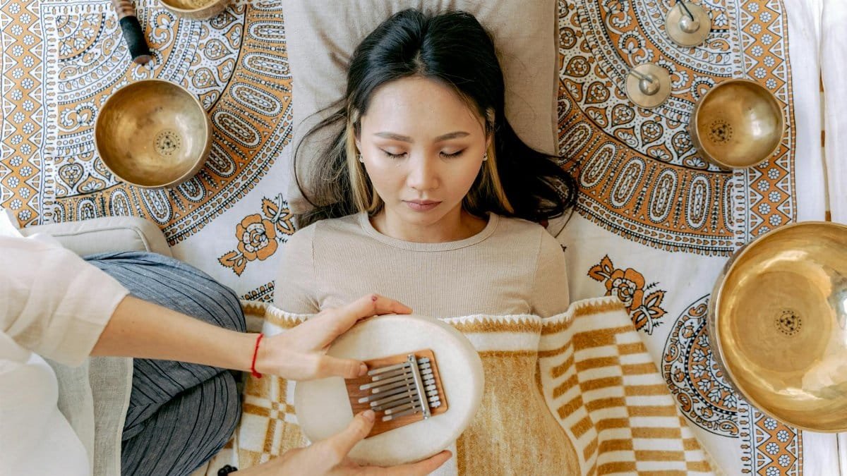 A serene meditation scene featuring a woman with kalimba and singing bowls, promoting relaxation and well-being.