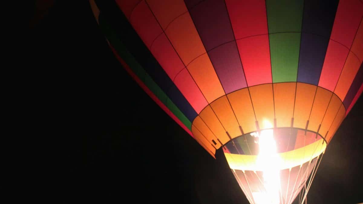 A vibrant hot air balloon illuminated against a night sky in St. Louis.