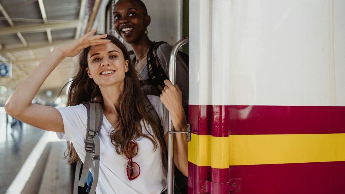 Two friends eagerly embark on a train journey, capturing the joy of travel.