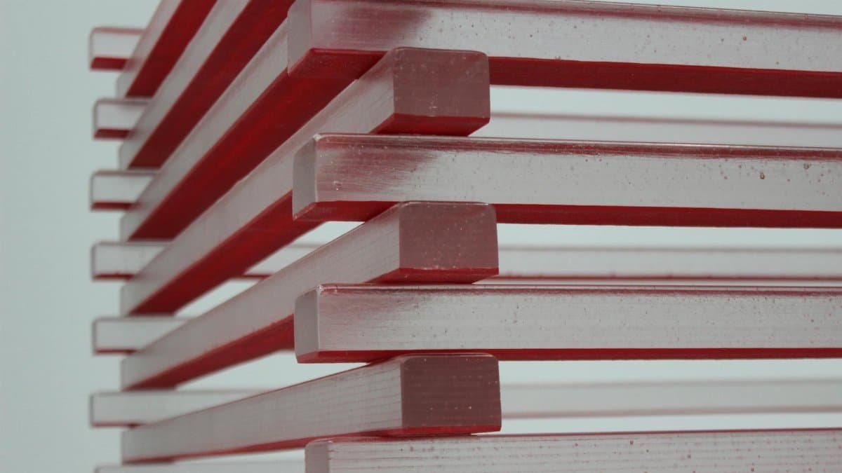 Close-up view of stacked red and clear blocks creating an abstract geometric pattern.