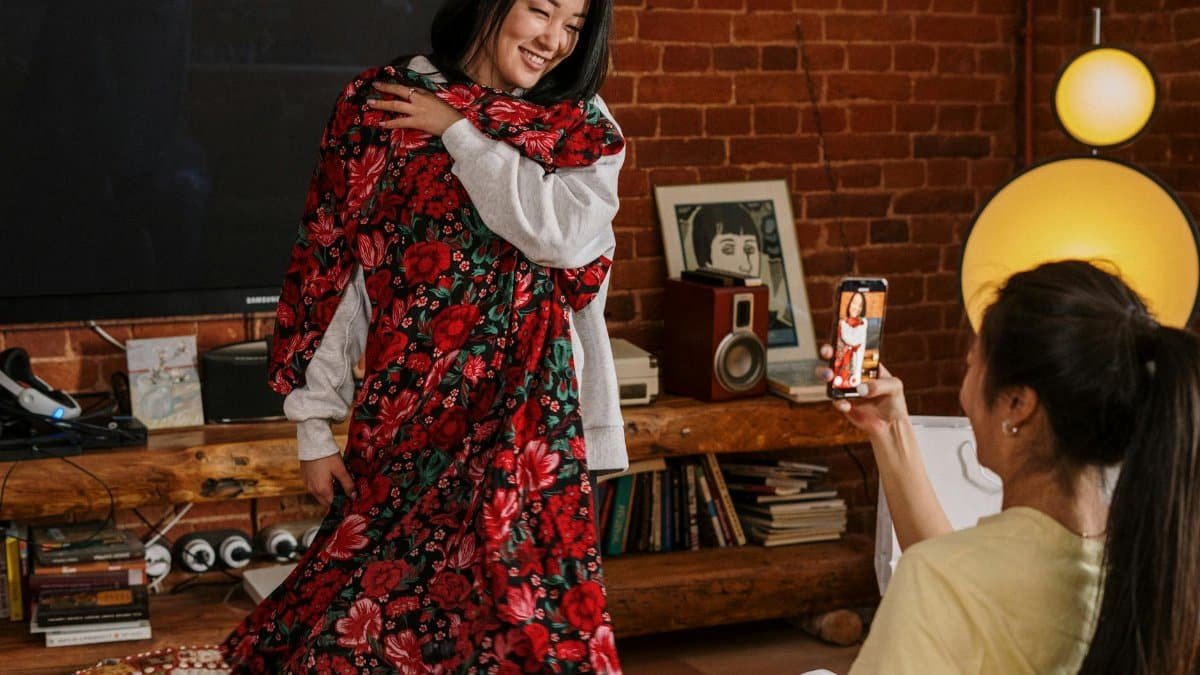 Two friends enjoying a fashion try-on session in a cozy living room.