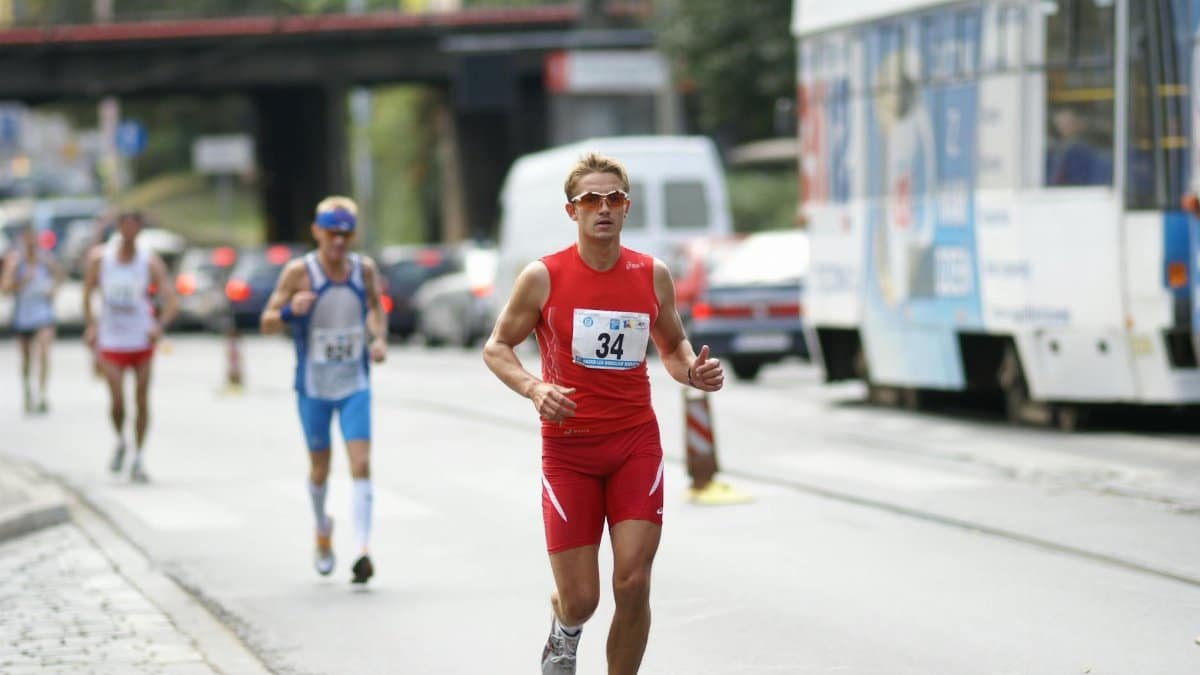 Focused athletes running in a street marathon during the day.