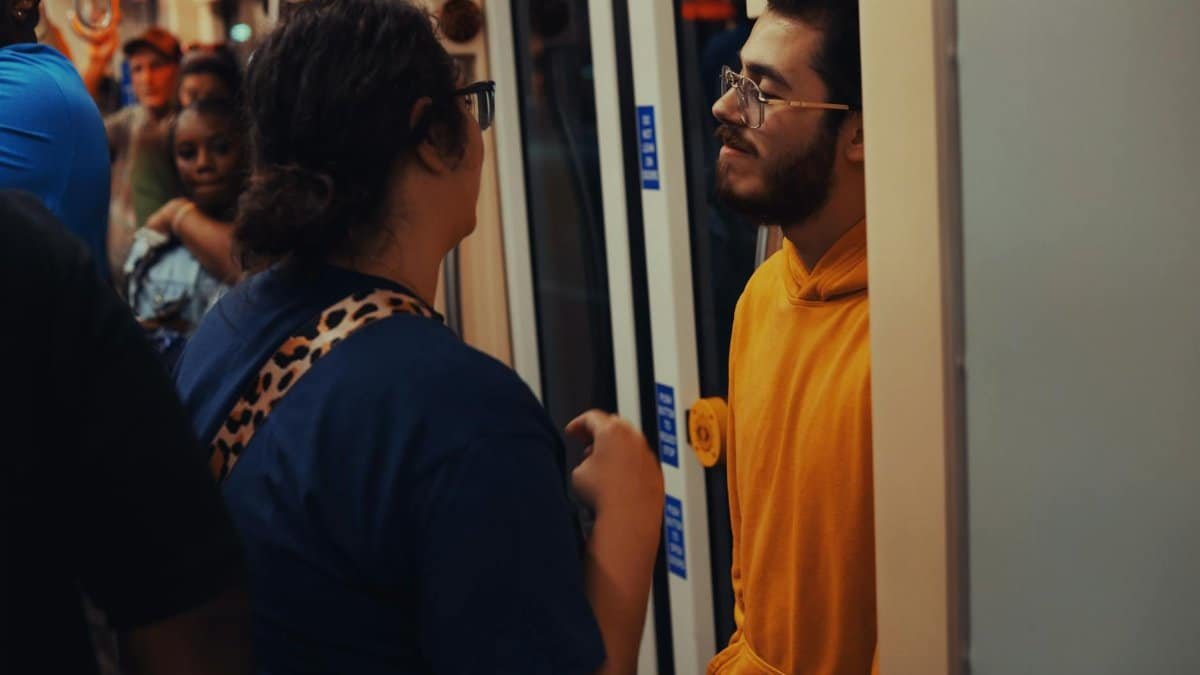 People interacting inside a Detroit metro train, an urban public transportation scene.
