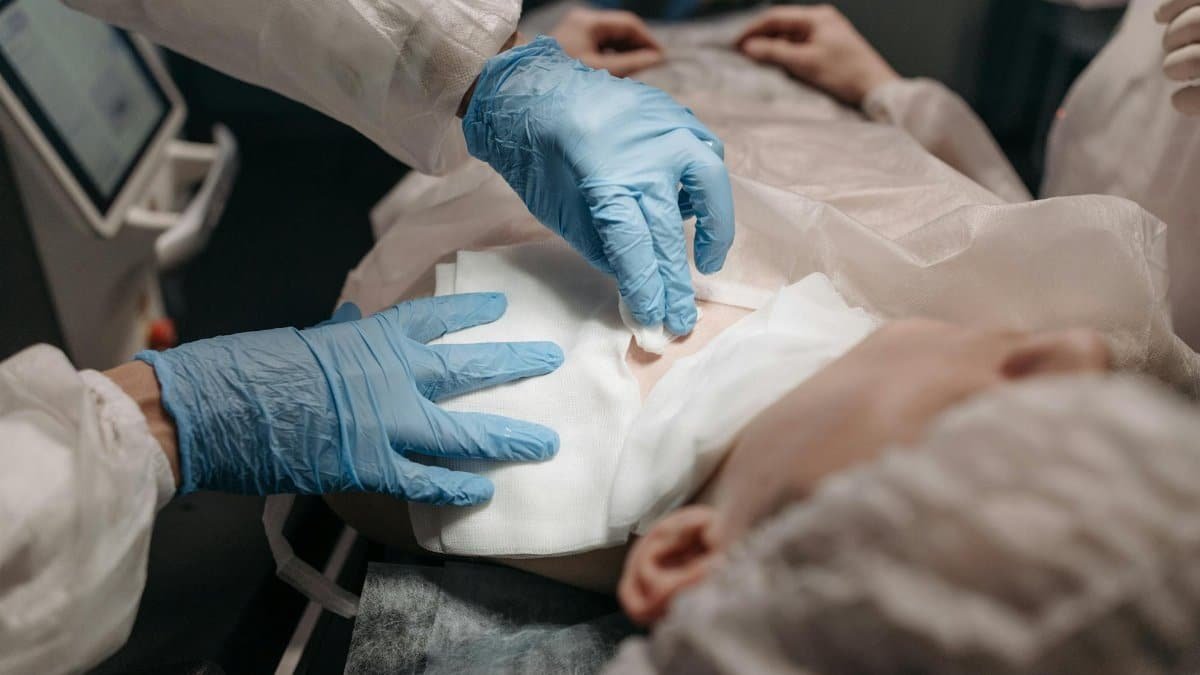 Doctors perform a medical procedure in a sterile environment, focusing on precision and care.