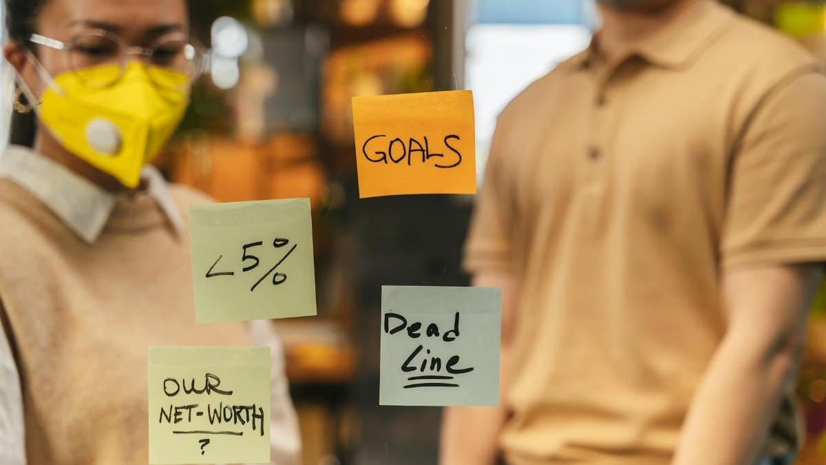 Office scene showcasing goals and deadlines on sticky notes during a brainstorming session.