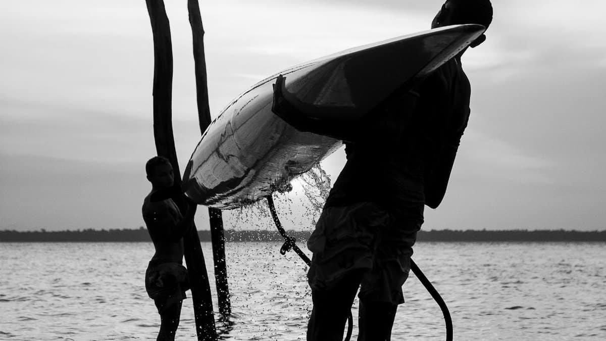 Two people prepare a canoe for launch in Belem, Brazil river, in striking black and white.