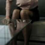 A wedding ring on a glass table symbolizes divorce and relationship issues.