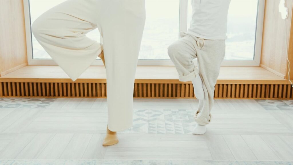 A mother and child practicing yoga indoors in a bright, calming room.