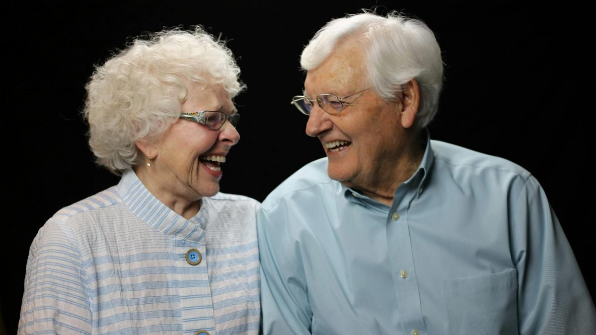 Elderly couple sharing a joyful moment with a loving laugh.