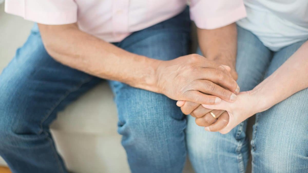 A touching close-up of a couple holding hands, symbolizing support and empathy.