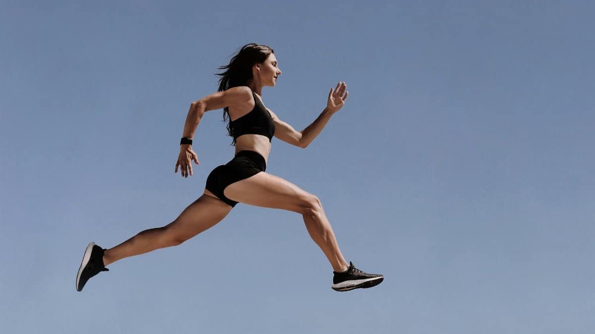 Athletic woman in motion leaping across the sky demonstrating energy and fitness outdoors.