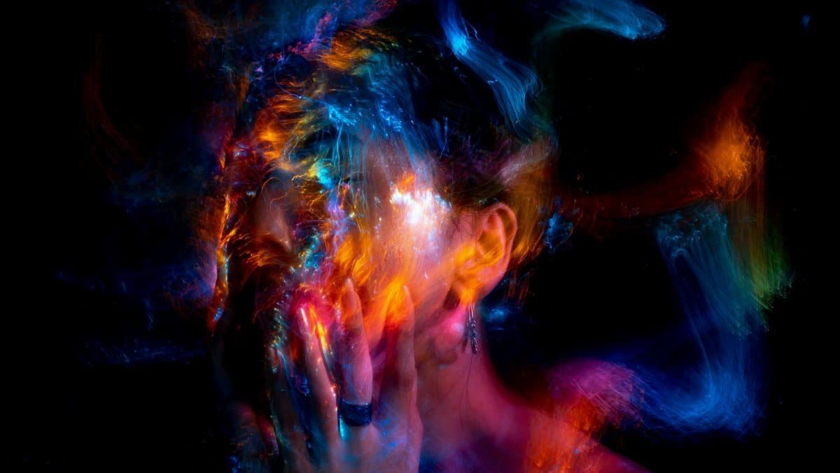 Vibrant long exposure portrait with colorful light painting effects.