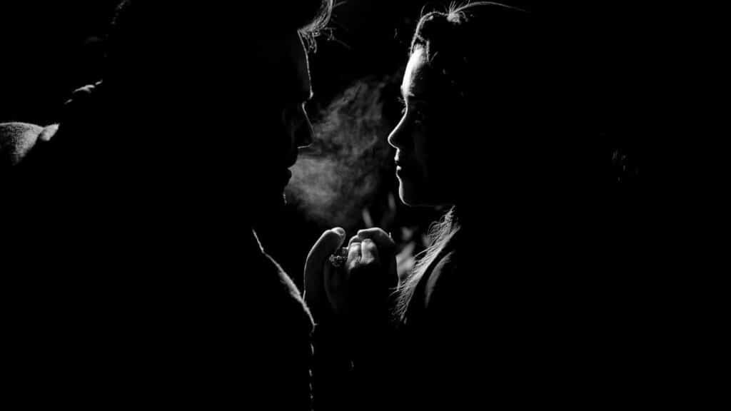 Two people silhouetted engaging in a deep conversation, dramatic lighting.