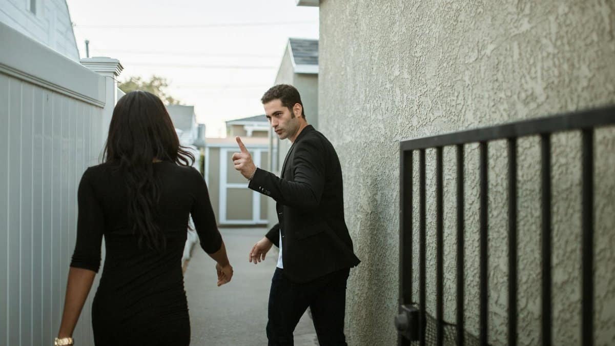 A couple having a tense argument in an outdoor alley, showcasing relationship conflict.