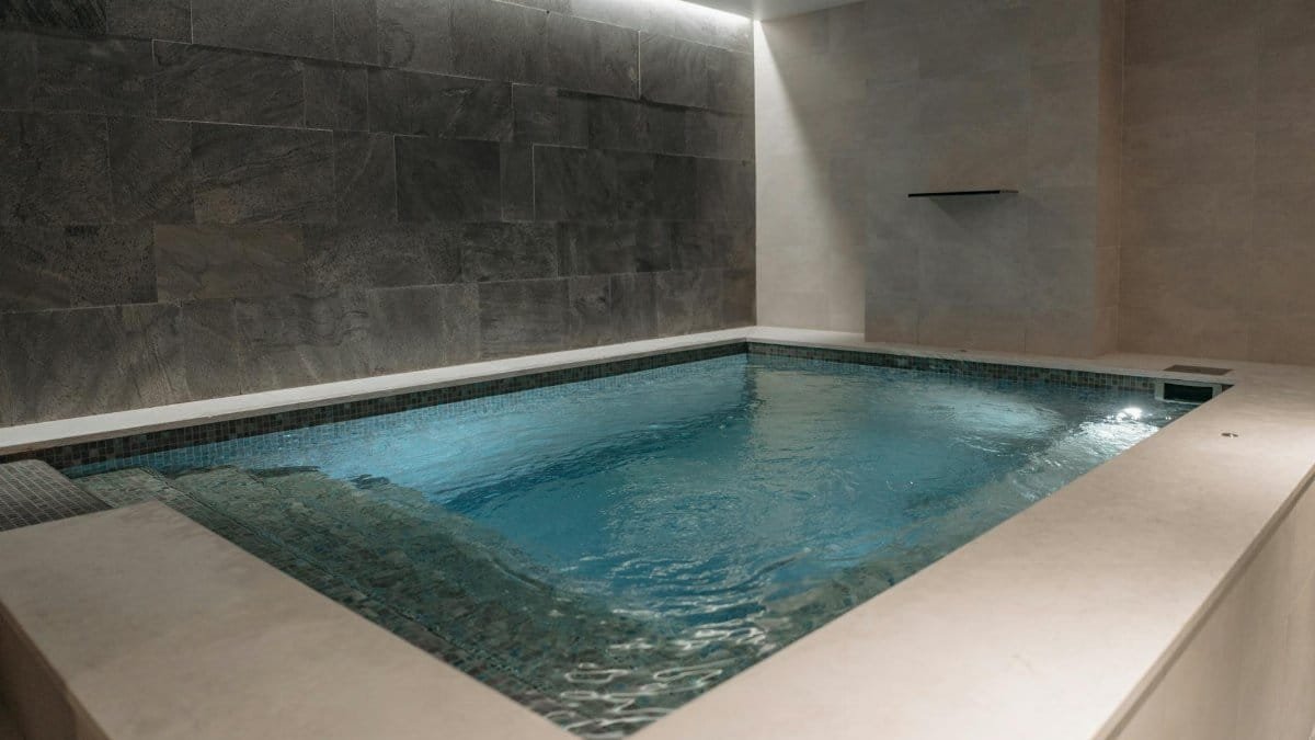 Elegant indoor spa pool with modern stone tile interior, perfect for relaxation.