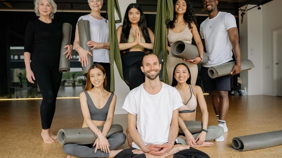 Smiling diverse group practicing yoga in a studio setting with positive energy.